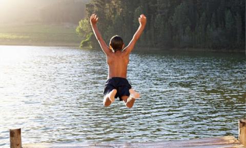 мальчик прыгает в воду