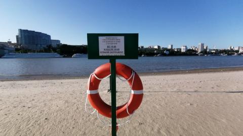 Табличка и спасательный круг на пляже