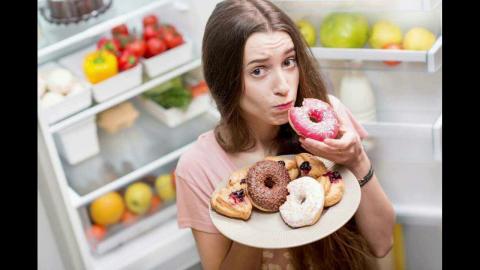 Девушка ест много сладостей