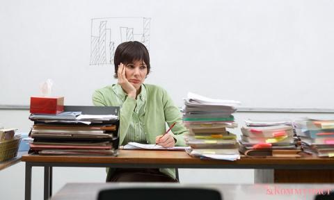 Учитель за столом с тетрадями