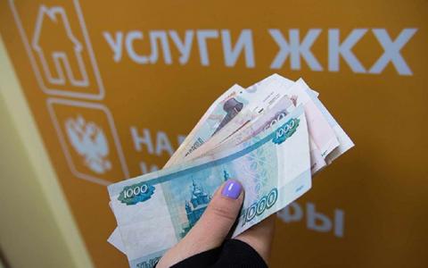 Пачка денег в руке Оплата услуг ЖКХ